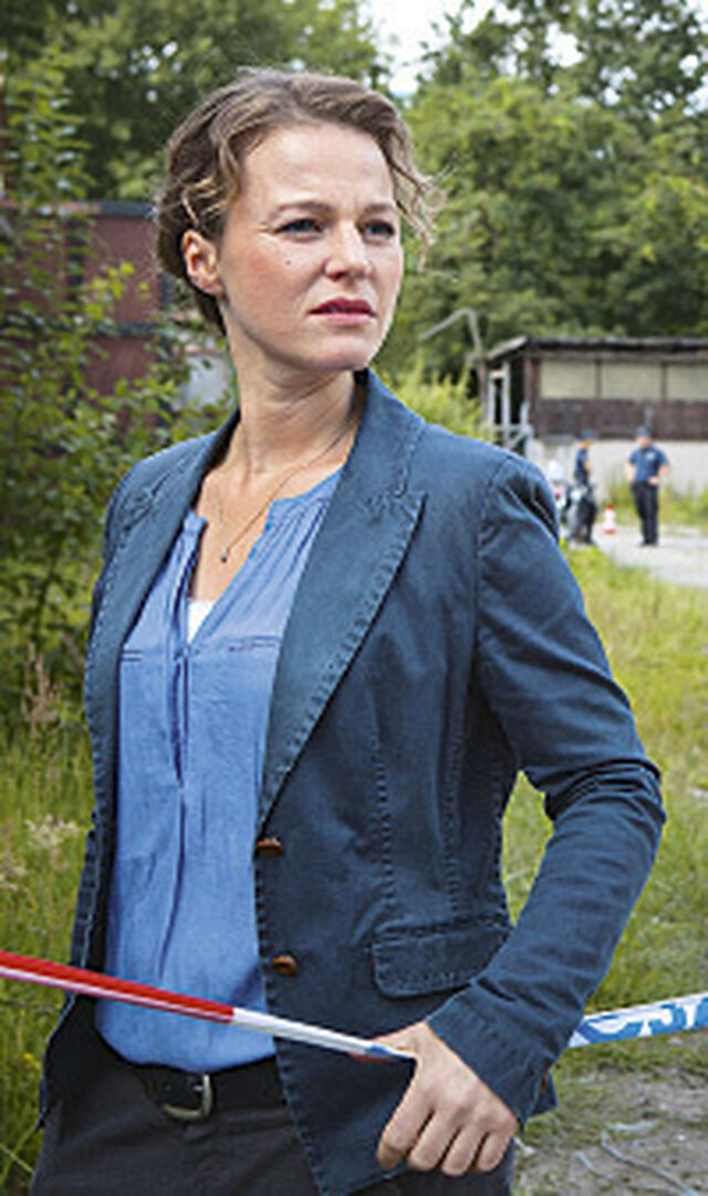 Maria Simon als Kriminalhauptkommissarin Olga Lenski im Polizeiruf 110 vor einer Absperrung stehend.