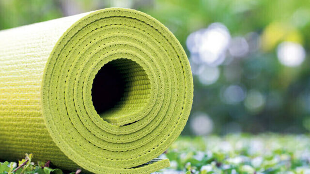 Eine zusammengerollte grüne Yogamatte