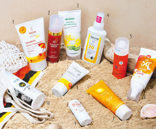 10 unterschiedliche Sonnenschutz-Produkte auf Sand
