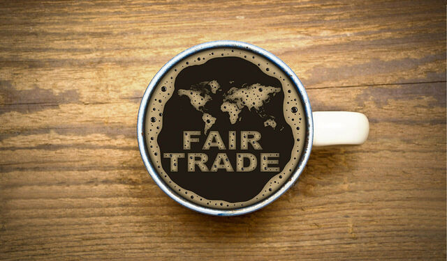 Eine Tasse Kaffee von oben mit Schaum, der die Wörter Fair Trade bildet