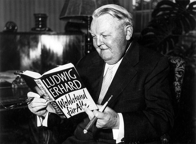 Der Politiker Ludwig Erhard mit einem Buch in der Hand