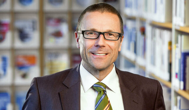 Porträtfoto von Prof. Dr. Uwe Schneidewind in Anzug und Krawatte. Er lächelt in die Kamera