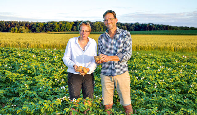 Petra Sandjohann und ihr Mann Bernhard Schreyer in ihrem Kartoffelfeld stehend.
