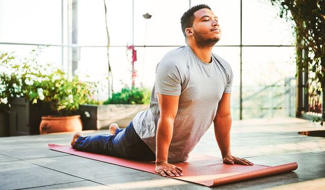 Mann auf einer Yogamatte, eine Turnübung machend