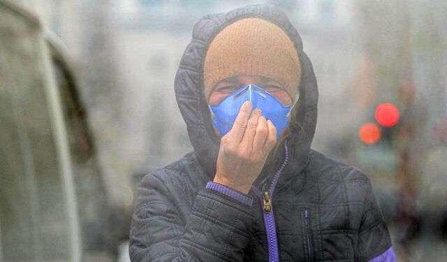 Mann mit FFP2-Maske auf Straße mit Smog.