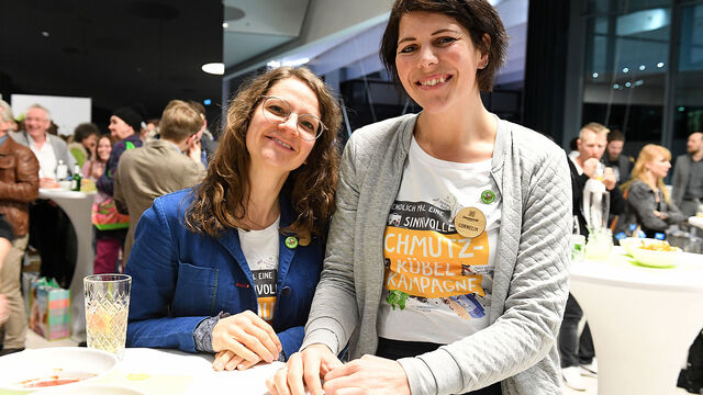 Zwei Mitarbeiterinnen von Sonnentor posieren lächelnd am Stehtisch.