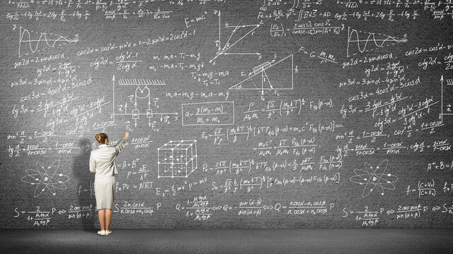 Eine Frau steht vor einer Tafel und schreibt Formeln auf