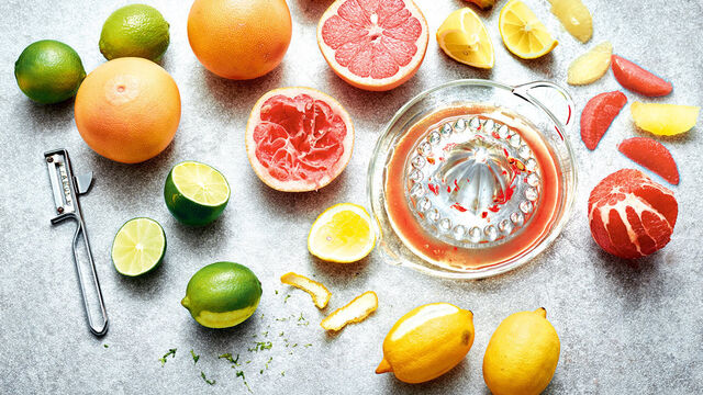 Zitrusfrüchte (Limetten, Grapefruit, Zitronen) auf einer Marmorplatte